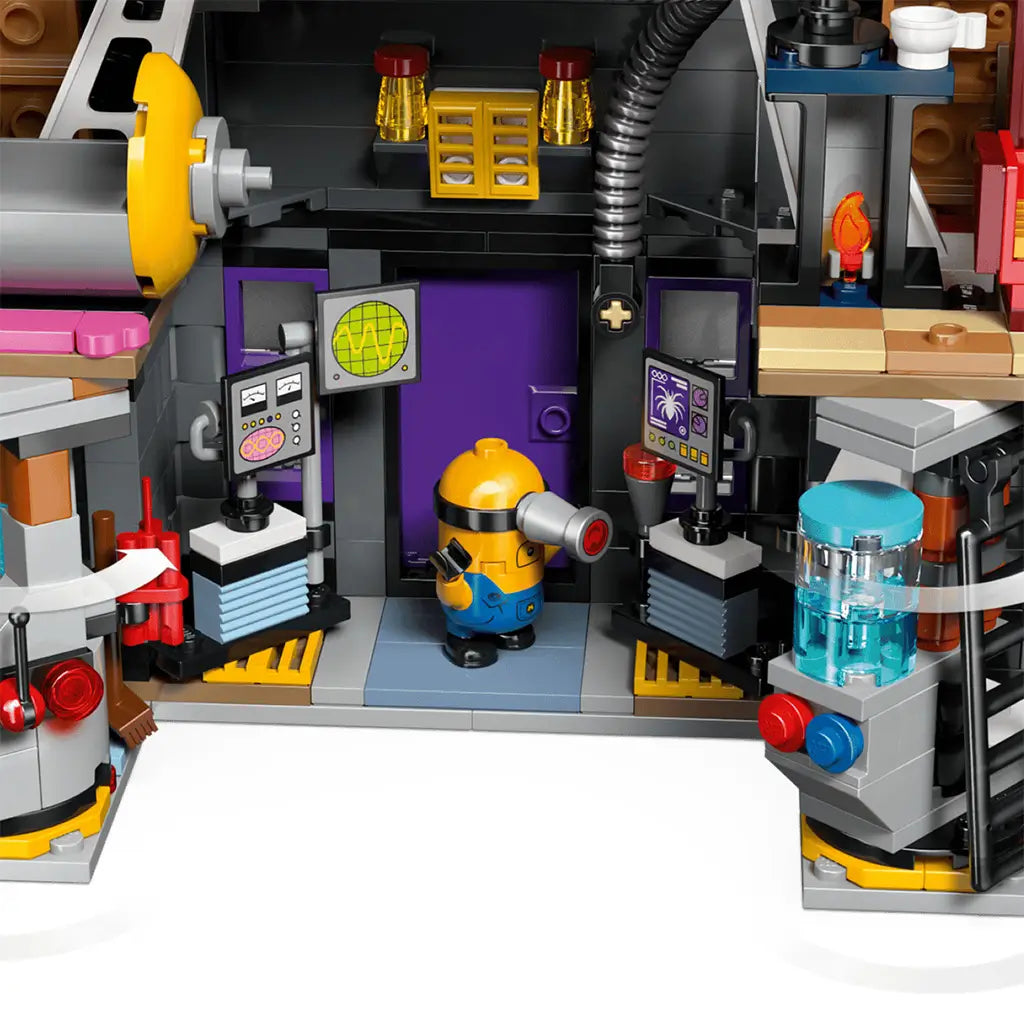 LEGO Despicable Me 4 laboratory interior in gray, black and purple plastic features a yellow Minion between control screens, pipes, a blue tank and equipment.