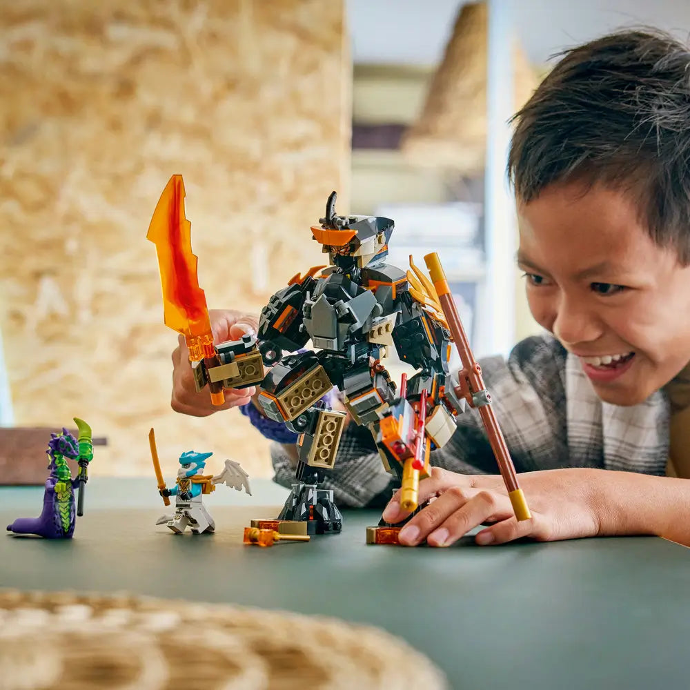 LEGO NINJAGO mech toy built from dark gray and gold plastic with translucent orange weapons, shown in use by a smiling child, emphasizing interactive play, poseable action, and imaginative ninja adventures.