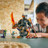 LEGO NINJAGO mech toy built from dark gray and gold plastic with translucent orange weapons, shown in use by a smiling child, emphasizing interactive play, poseable action, and imaginative ninja adventures.