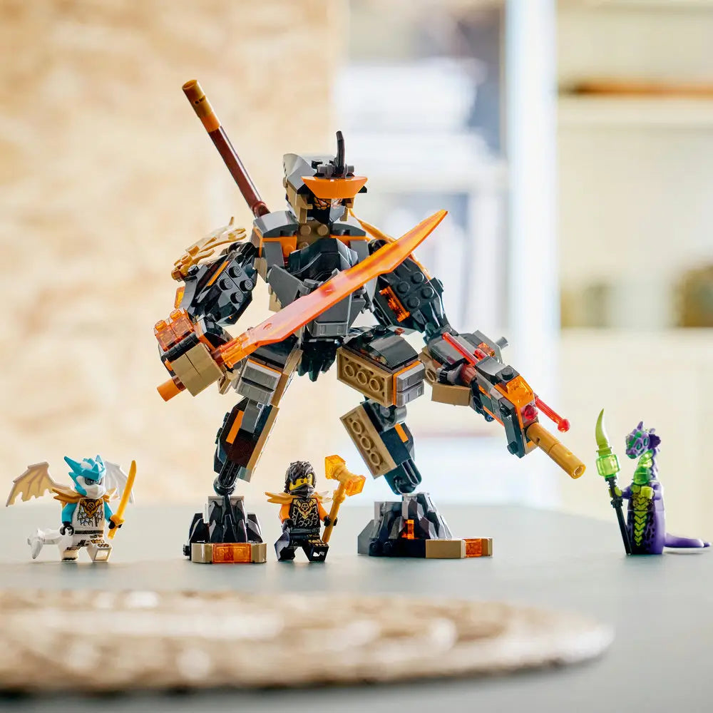 LEGO NINJAGO playset arranged on a tabletop with a completed dark gray and gold mech, articulated stance, translucent orange blade, and minifigures lined up to show finished build and display-ready details.