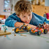LEGO NINJAGO vehicle set in red, black and gold plastic is played with by a smiling child, with Kai's buggy, Cole's motorcycle and an icy figure on a white table.