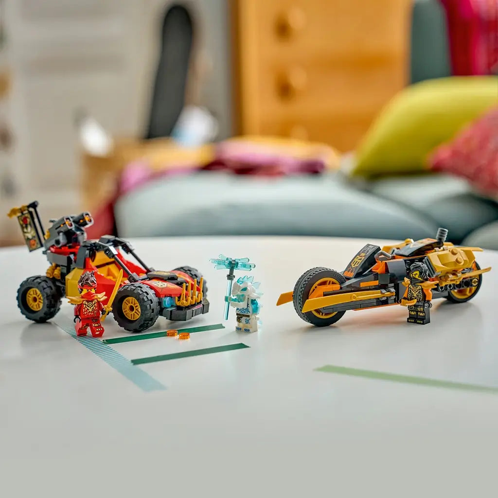 LEGO NINJAGO vehicle set in red, black and gold plastic displays Kai's buggy and Cole's motorcycle with three figures and weapons on a white table in a home setting.