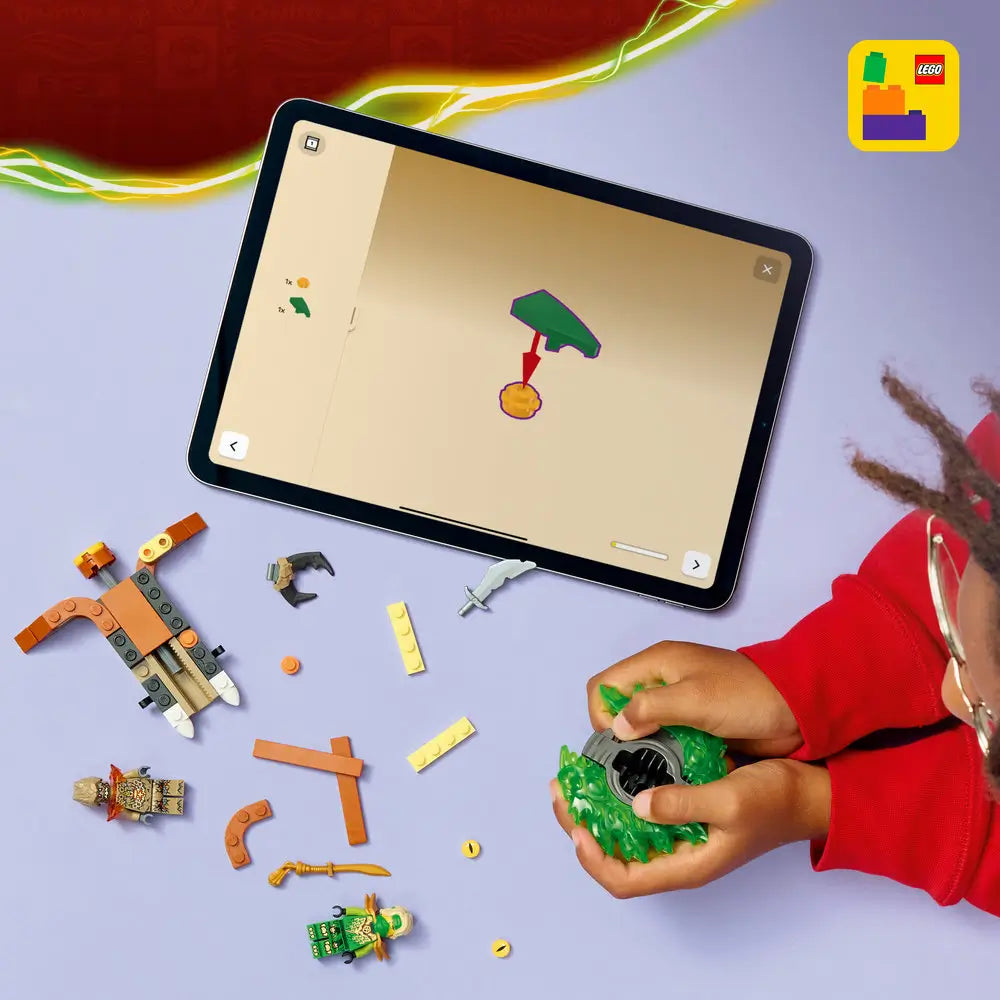LEGO NINJAGO building pieces in green, brown, and gold plastic are arranged on a light surface as a child assembles a spinner, with a tablet displaying digital instructions nearby.