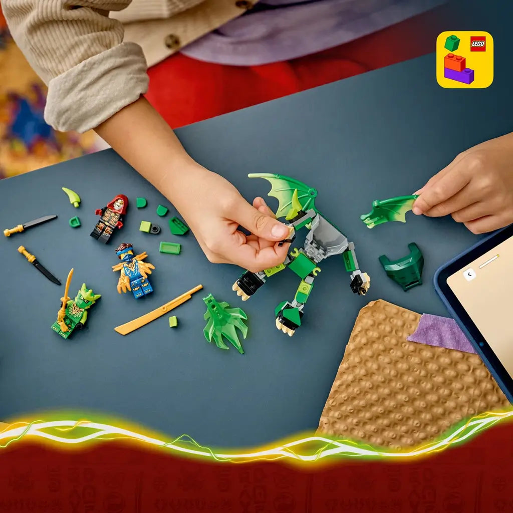 LEGO NINJAGO dragon mech set in green, gray and gold bricks is assembled by a child on a blue table, with loose parts, three minifigures, and LEGO Builder icon.