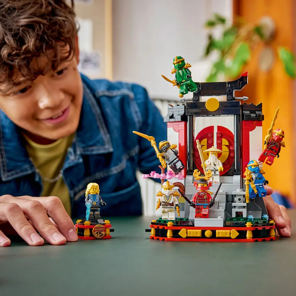 LEGO NINJAGO Legacy temple play scene showing a child assembling the red and black shrine structure, with ninja minifigures, weapons, and parts spread out for hands-on creative indoor play.