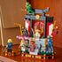 LEGO NINJAGO Legacy ninja temple display fully assembled in red, black, gray, and gold plastic, presented on a tabletop with multiple ninja minifigures posed around the shrine in a home setting.