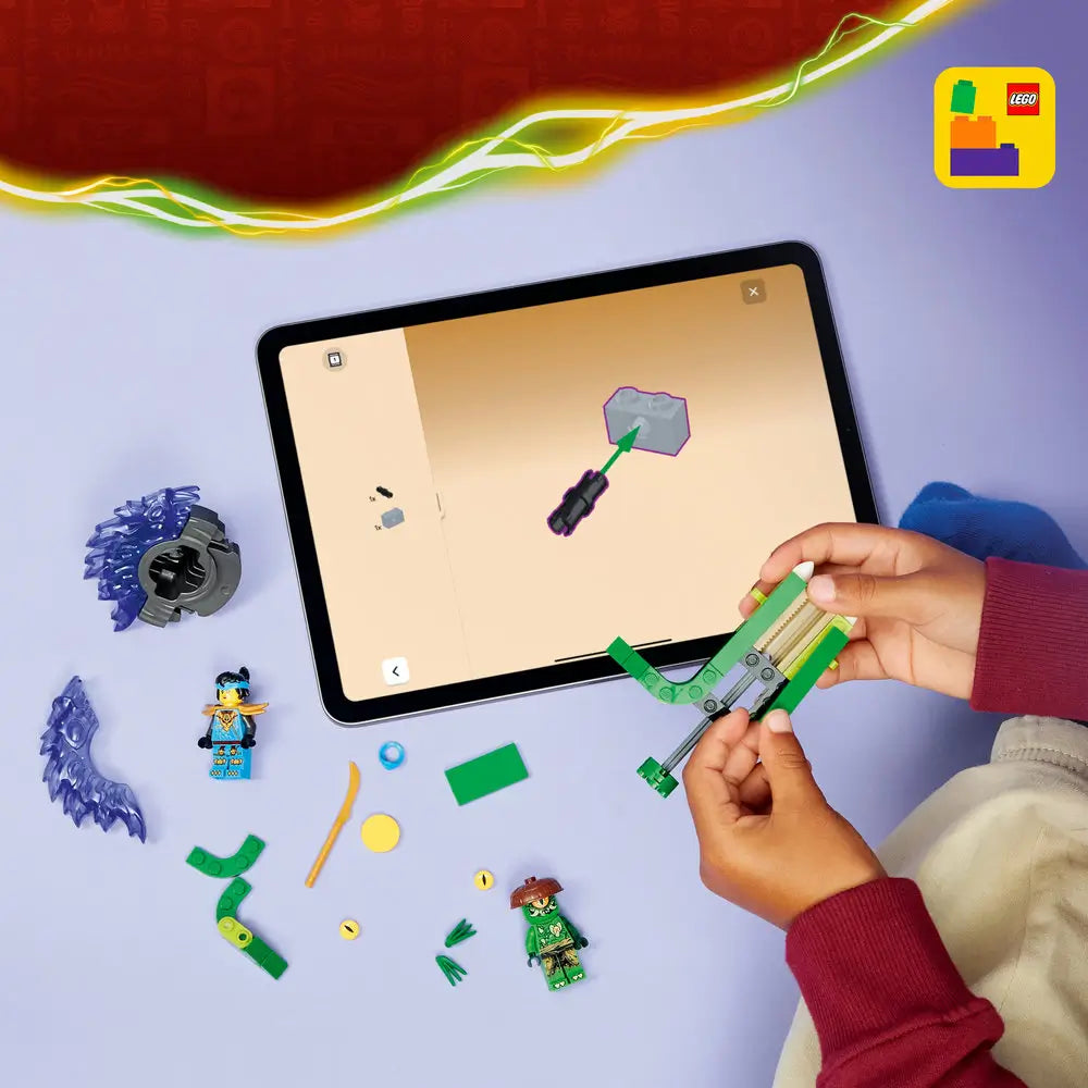 LEGO NINJAGO building pieces in green, blue, and gold plastic are spread on a light surface as hands assemble a spinner launcher, with a tablet displaying digital step by step instructions nearby.