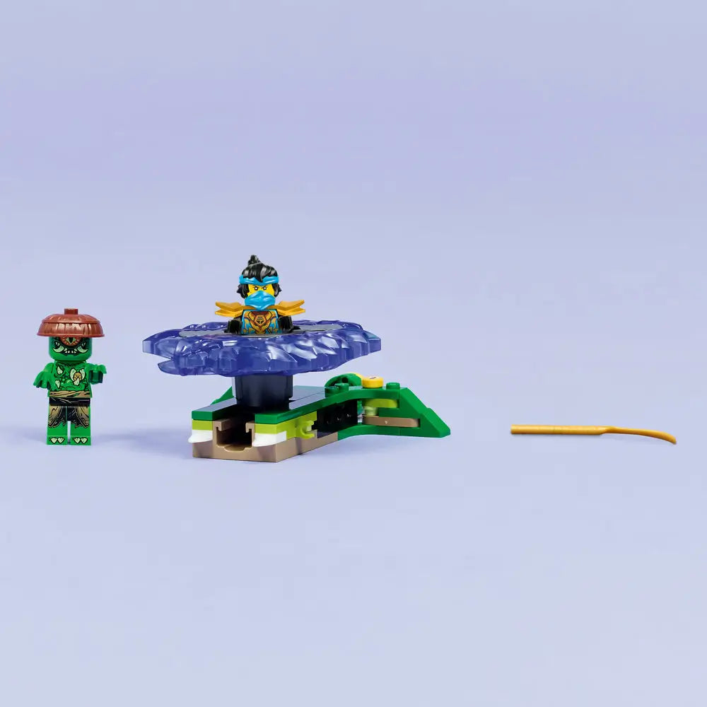LEGO NINJAGO spinner build is displayed with a translucent purple spinning base, mutation monster figure, blue ninja minifigure, and launcher piece arranged neatly on a plain light background.