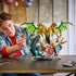 LEGO NINJAGO Ultra Dragon Battle in gold, white and green plastic shows a builder posing a red ninja beside the four-headed dragon and serpent on a tabletop display.