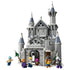 LEGO One Piece Battle at Drum Castle model uses gray plastic bricks, blue-gray turret roofs, snowy accents, an arched entrance, and six minifigures on a white background.
