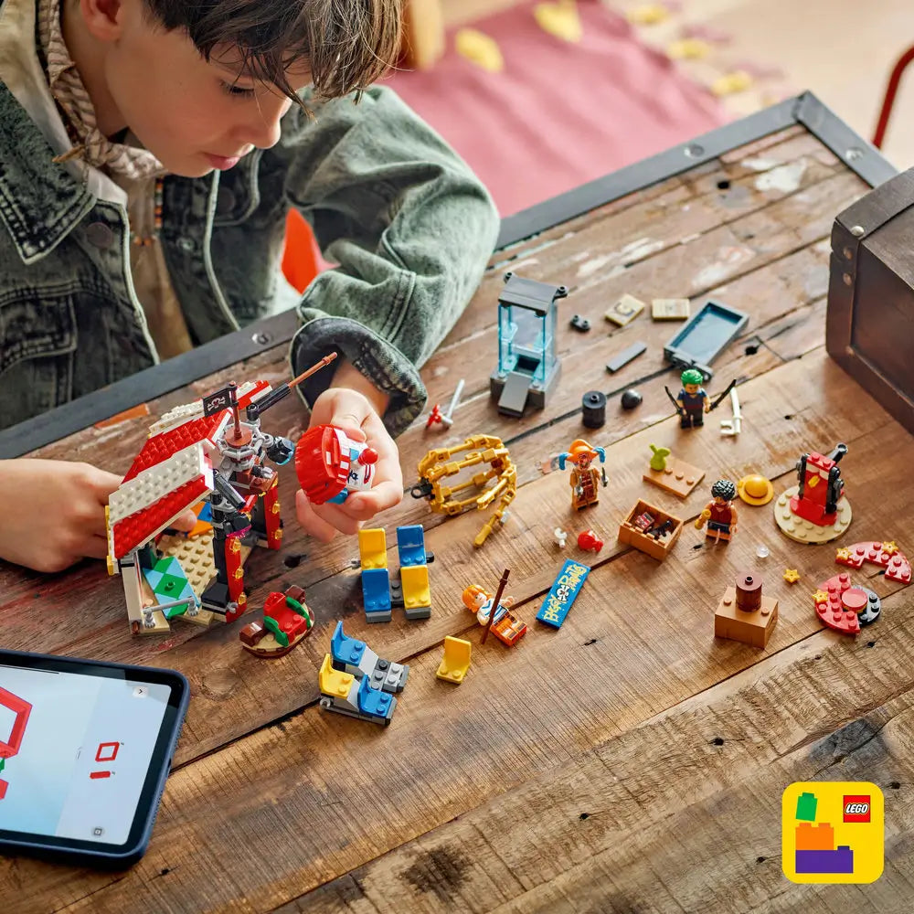 LEGO ONE PIECE Buggy the Clown's Circus Tent build in colorful plastic as a child assembles the circus playset and minifigures beside digital building instructions on a wooden table.
