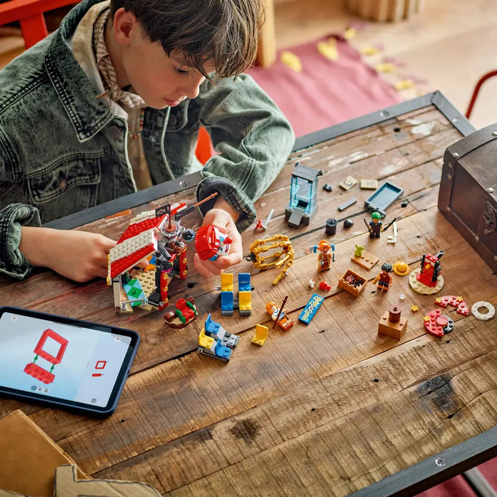LEGO ONE PIECE Buggy the Clown's Circus Tent pieces spread across a wooden table as a child builds the colorful circus attraction with character minifigures and accessories.