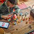 LEGO ONE PIECE Buggy the Clown's Circus Tent pieces spread across a wooden table as a child builds the colorful circus attraction with character minifigures and accessories.