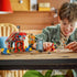 LEGO ONE PIECE Buggy the Clown's Circus Tent displayed in red, white and blue plastic while a smiling child recreates scenes with Buggy, Luffy, Nami and Zoro indoors.