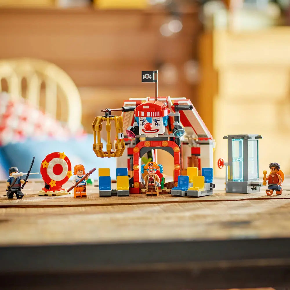 LEGO ONE PIECE Buggy the Clown's Circus Tent model in red, white and blue plastic with circus façade, spinning target, cage and character minifigures displayed on a tabletop.