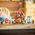 LEGO ONE PIECE Buggy the Clown's Circus Tent model in red, white and blue plastic with circus façade, spinning target, cage and character minifigures displayed on a tabletop.