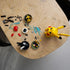 LEGO Pokémon Pikachu building set shows yellow, red, black and clear plastic pieces, curved character sections and display components arranged for assembly across a light stone tabletop workspace.