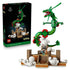 LEGO Pokémon Rayquaza set in green plastic bricks forms a long dragon above a tan shrine and white clouds, shown beside the black 1083-piece product box.