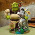 LEGO Shrek display model features green Shrek, gray Donkey and orange Puss in Boots on a tan swamp base with sunflowers, green plants and a Beware Ogre sign indoors.