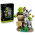 LEGO Shrek display set pairs its black retail box with green Shrek, gray Donkey and orange Puss in Boots brick figures on a detailed swamp-themed display base.