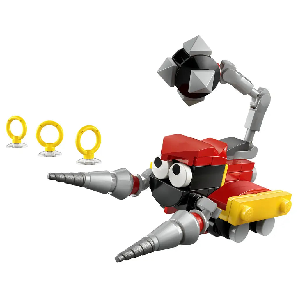 LEGO Sonic the Hedgehog Badnik Skorp toy model showing red, black, and gray plastic bricks, angular mechanical body, drill-shaped arms, jointed tail, and collectible golden rings, displayed on a clean white background.