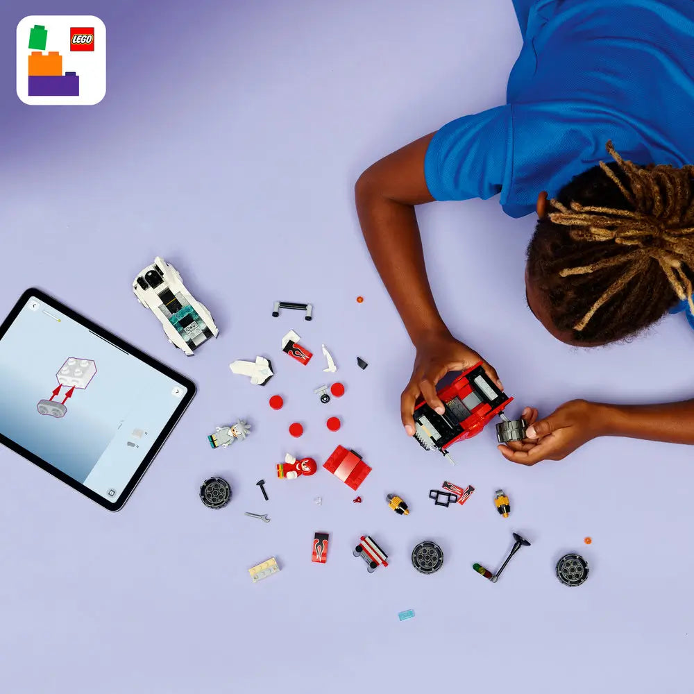 LEGO Sonic the Hedgehog building pieces in red, white, black, and gray plastic with wheels, character parts, and small accessories, scattered flat for assembly to clearly show all components on a smooth light surface.