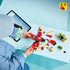LEGO Sonic the Hedgehog Tails' Tornado-1 build scene shows a child assembling the red and yellow brick airplane beside loose pieces, Tails, a green Badnik and a tablet.