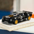 LEGO Speed Champions Ford Mustang Hoonicorn in glossy black plastic features gold wheels, Hoonigan graphics and a rear spoiler, displayed on a book in a softly lit room.