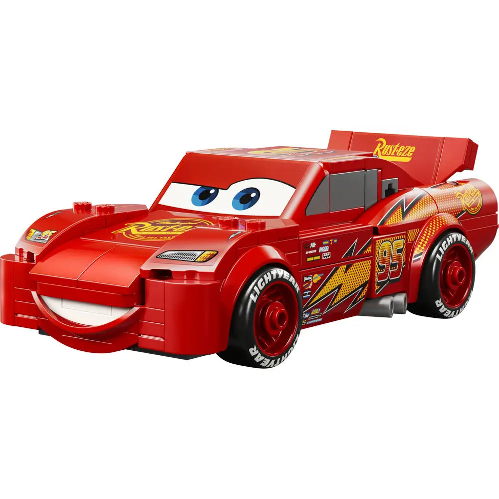 LEGO Lightning McQueen race car model in bright red plastic with smooth curved body, printed blue eyes, Rust-eze graphics, number 95 decals, and black racing wheels, displayed as a Disney Pixar Cars character on a white background