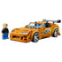 LEGO Speed Champions Toyota Supra MK4 in orange plastic features silver wheels, green side graphics, clear engine details and a gray rear wing beside a driver minifigure.