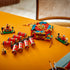 Completed LEGO Fortune Firecracker model displayed on a table, featuring red cylindrical firecrackers, gold accents, teal details, and Spring Festival minifig scenes on small bases