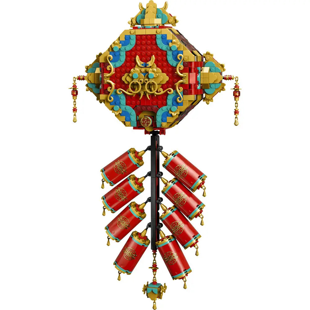 LEGO Fortune Firecracker wall decoration in red, gold, and teal plastic with layered geometric panels, ornate scrollwork, and hanging firecracker cylinders, designed as a festive Spring Festival display on a white background
