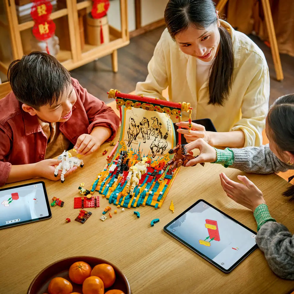 Family building the LEGO Galloping Horses Canvas set at a wooden table, with colorful bricks, four horse figures, tablets showing instructions, and a warm indoor Spring Festival setting