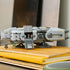 LEGO Star Wars Anzellan Starship display features a gray plastic spacecraft with rounded body panels, opening side compartment and character figures, showcased on stacked books in a home interior.