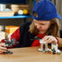 LEGO Star Wars AT-RT Attack play scene shows a child using a gray plastic walker and white turret build with minifigures, recreating action adventures on a tabletop indoors.