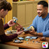 LEGO Star Wars Boba Fett build in green, gray and tan plastic bricks, assembled by two adults at a wooden table with loose pieces, smartphone and tablet instructions.