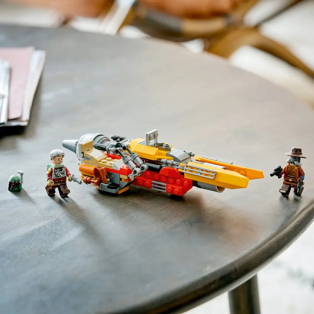 LEGO Star Wars speeder model in yellow, red, and gray plastic fully assembled, displayed with minifigures standing nearby on a smooth tabletop in a neutral indoor setting.