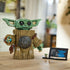 LEGO Star Wars Grogu model features a green brick-built head, tan textured robe and round silver accessory, displayed beside an information plaque on a wooden table in a home setting.