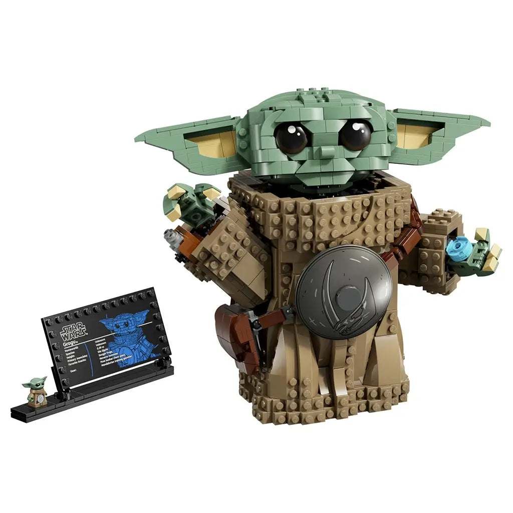 LEGO Star Wars Grogu collectible features a green brick-built figure with large ears, tan textured robes, silver accessory and display plaque on a light studio background.