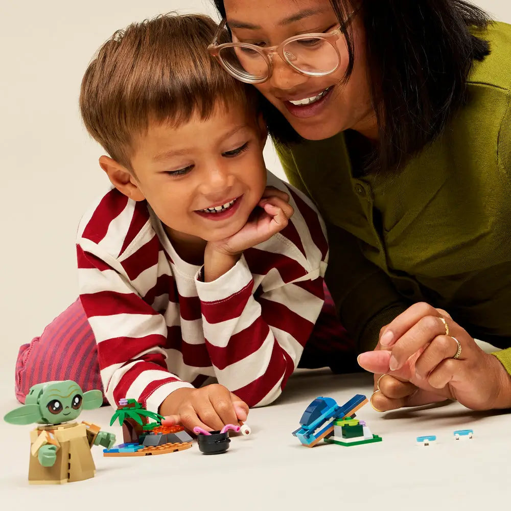 LEGO Star Wars play scene showing an adult and child interacting with the Grogu figure and homestead builds, highlighting shared play, simple construction steps, and imaginative storytelling.