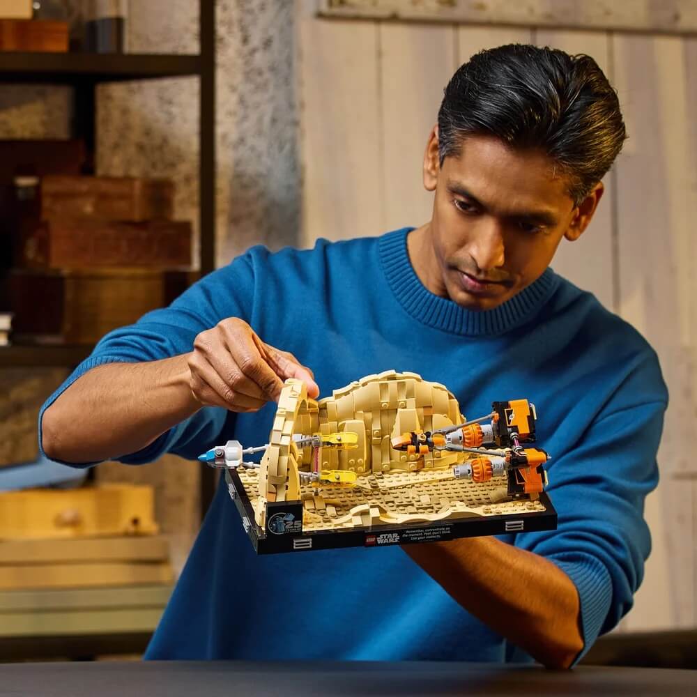 Image of a man wearing blue shirt while playing LEGO® Star Wars™ Mos Espa Podrace™ Diorama 718 Piece Building Set (75380)