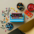 LEGO Donkey Kong Arcade build in blue, black and red plastic bricks, partially assembled from above among colorful beams, barrels, stars and trays of pieces on a tabletop.