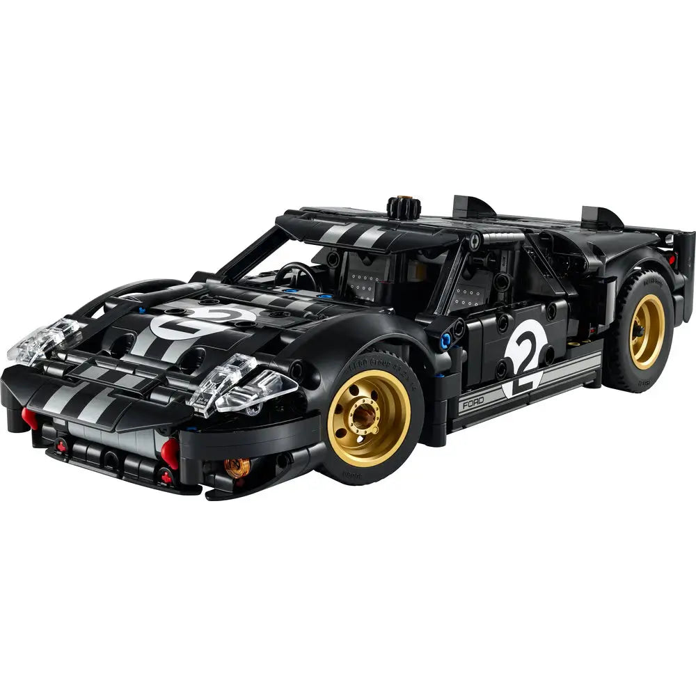 LEGO Technic Ford GT40 Mk II model features black plastic Technic panels with white racing stripes, gold wheels, low aerodynamic body, number two decals, and detailed headlights displayed on a clean white background.