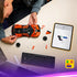 LEGO Technic Bugatti Chiron Pur Sport building scene shows orange Technic chassis and loose parts spread on a desk as a builder assembles the supercar using digital instructions on a tablet in a modern workspace.