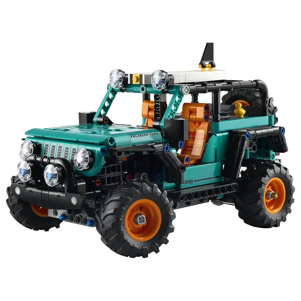 LEGO Technic Jeep Wrangler Rubicon model displays a teal plastic body with black frame, large rubber tires, orange accents, and detailed headlights, representing a rugged off road SUV, isolated on a clean white background for product display.