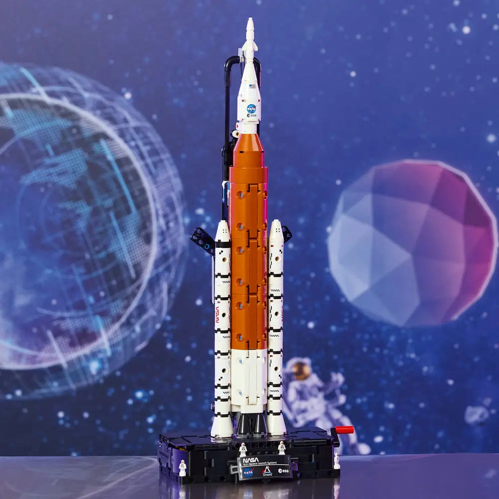 LEGO Technic NASA Artemis Space Launch System model displayed upright with white boosters, orange core stage, launch platform, and realistic proportions staged against a dramatic illustrated outer space background.