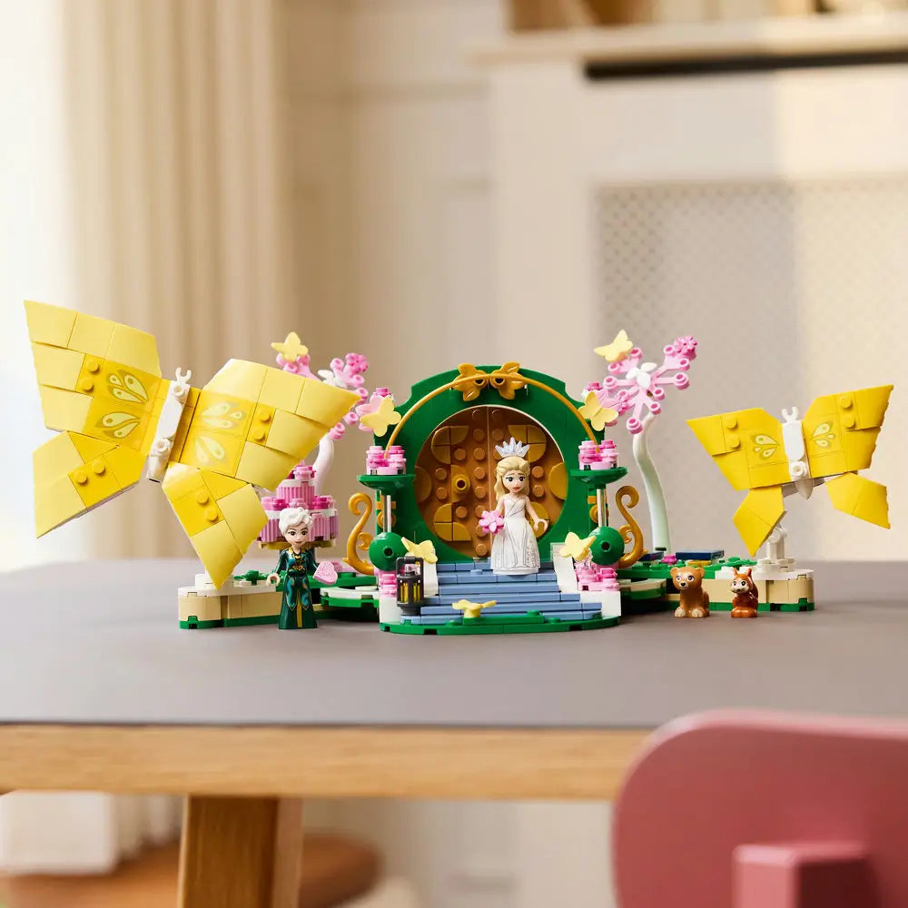 LEGO Wicked Glinda's Wedding Day playset displays butterfly models, floral decorations, mini-dolls and animal figures arranged on an indoor tabletop with detailed LEGO elements and realistic display presentation.