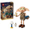 LEGO Harry Potter Dobby the Free Elf set 76469 in tan plastic bricks, with large green eyes, brown shoes, star effects, blue book, lamp and skeleton beside the retail box.