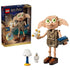 LEGO Harry Potter Dobby the Free Elf set 76469 in tan plastic bricks, with large green eyes, brown shoes, star effects, blue book, lamp and skeleton beside the retail box.