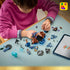 LEGO Harry Potter Forbidden Forest build is assembled by a child in a pink top, with brown tree sections, blue branches, minifigures, and a tablet spread across a table.